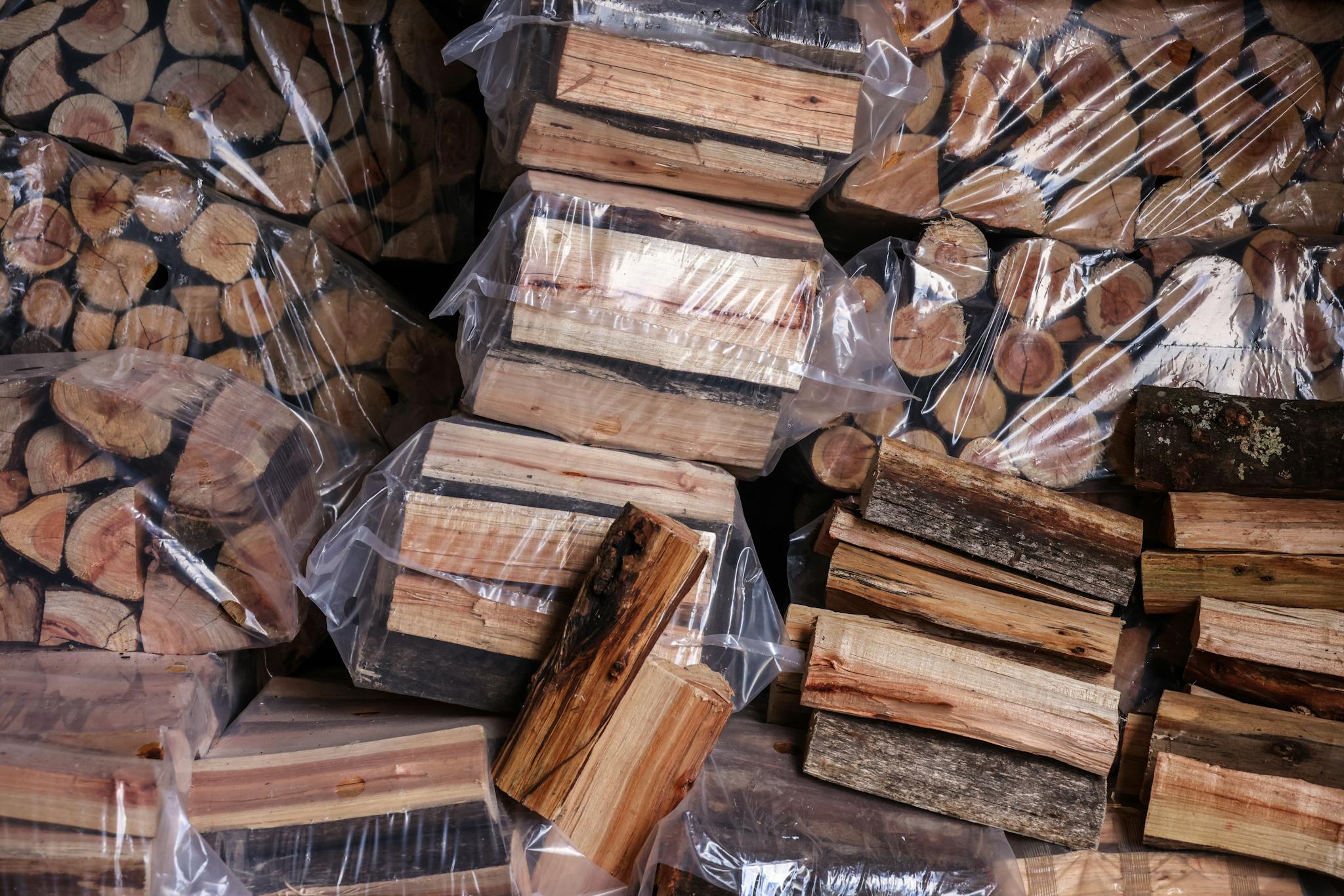 Neatly stacked firewood bundles wrapped in plastic, ideal for winter heating.